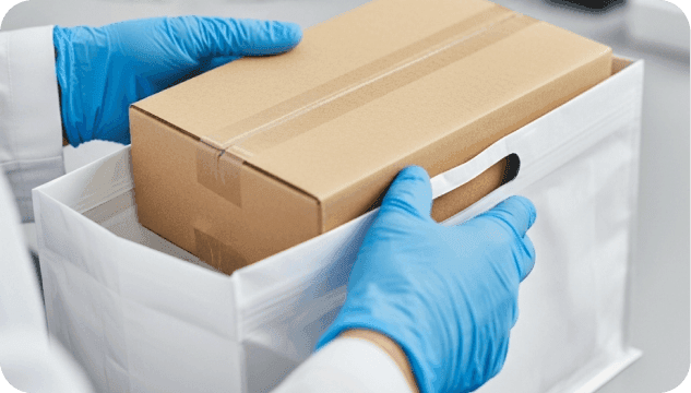 Händepaar mit Box in neutrale Tasche gelegt